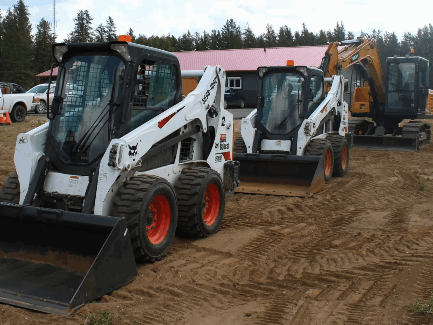 Skid steers lined up on dirt