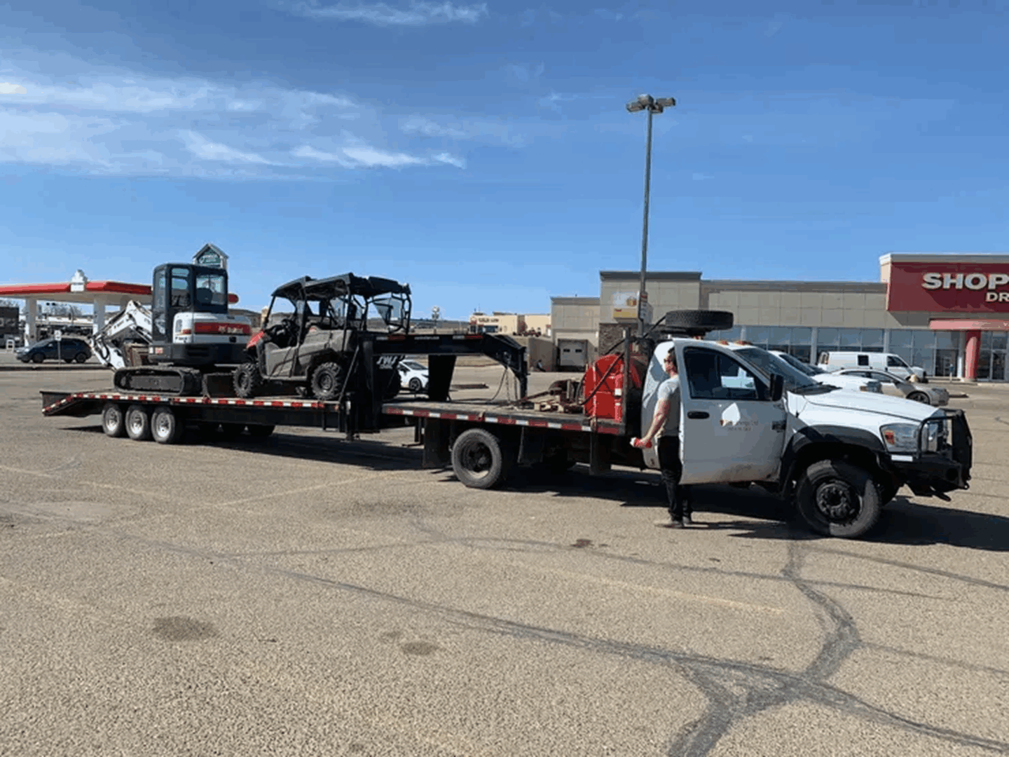 Flatbed trailer carrying utility vehicles