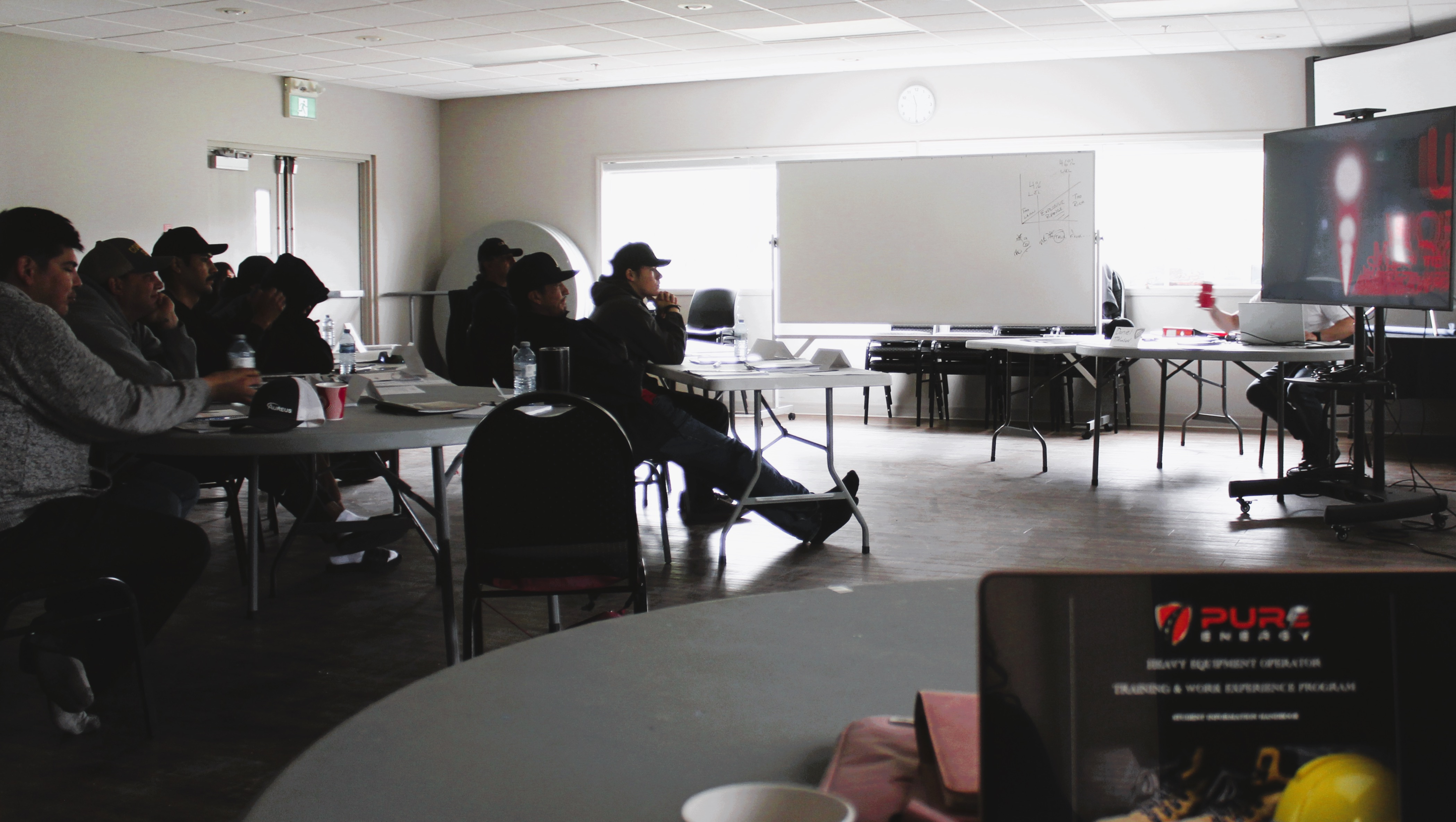 People attending a presentation in a dimly lit room.