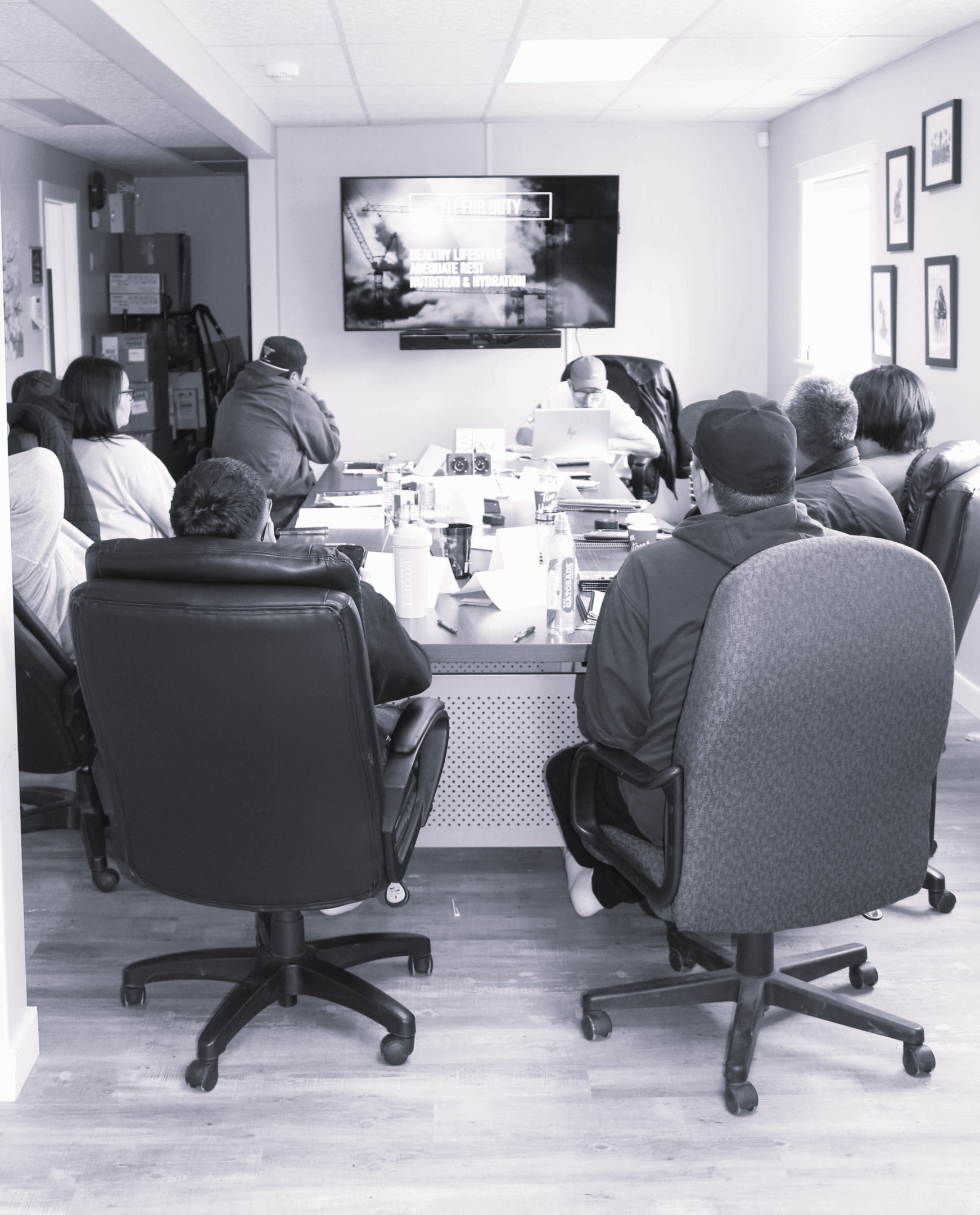 Team meeting discussing ideas around a conference table with a screen.